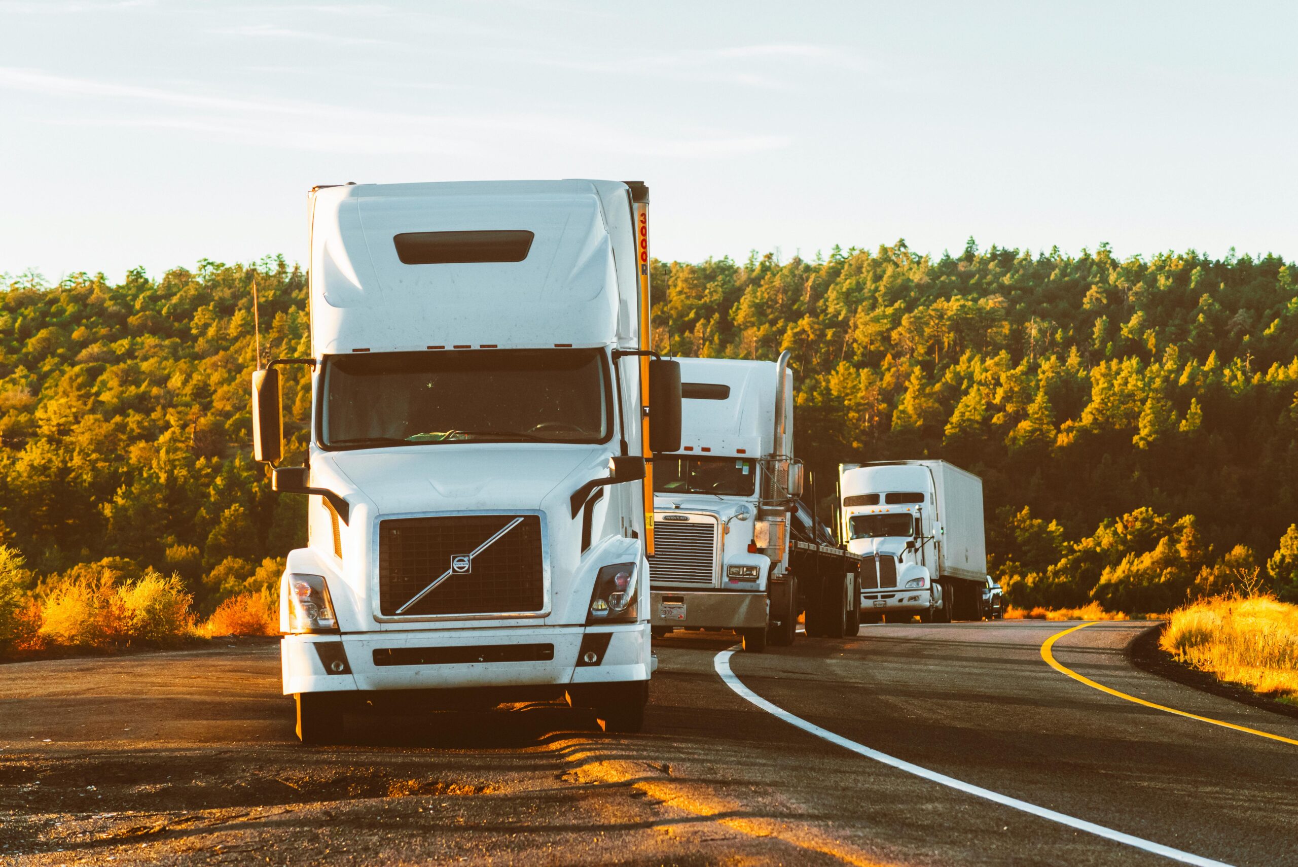Three trucks driving behind each other, showcasing safe driving practices for avoiding trucking accidents